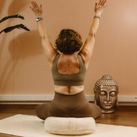 Pack Harmonie avec tapis de yoga Dhodra et coussin de méditation Moun en laine mérinos - yogi femme assise sur le coussin les bras levés - My Shop Yoga
